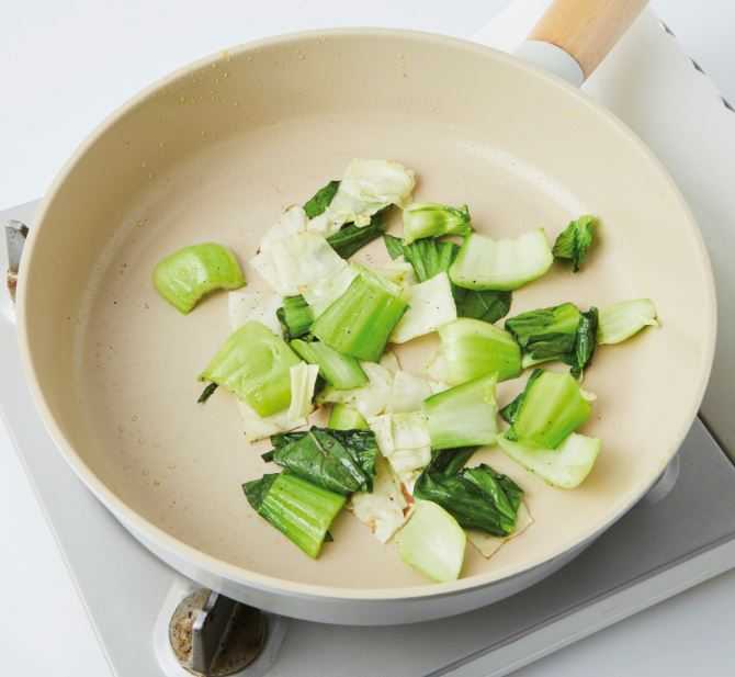 4. 같은 팬에 식용유(15㎖)를 두른 뒤 한입 크기로 썬 양배추와 청경채, 후춧가루(0.5g)를 넣어 3분간 볶아 꺼낸다.
