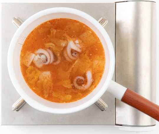 4. 멸치육수에 묵은지, 낙지, 고춧가루, 무, 마늘을 넣고 끓인다.